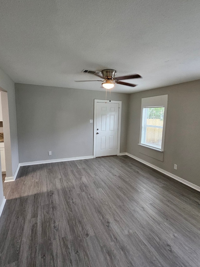 spare room featuring ceiling fan, a textured ceiling, and dark hardwood / wood-style floors