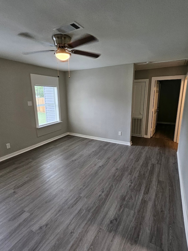 unfurnished room with ceiling fan, a textured ceiling, and dark hardwood / wood-style flooring