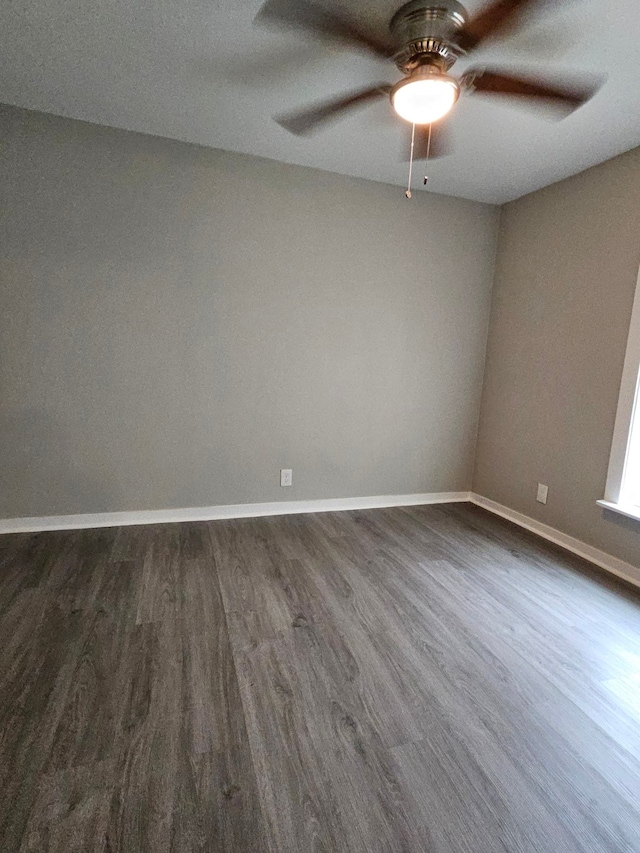 empty room with dark wood-type flooring and ceiling fan