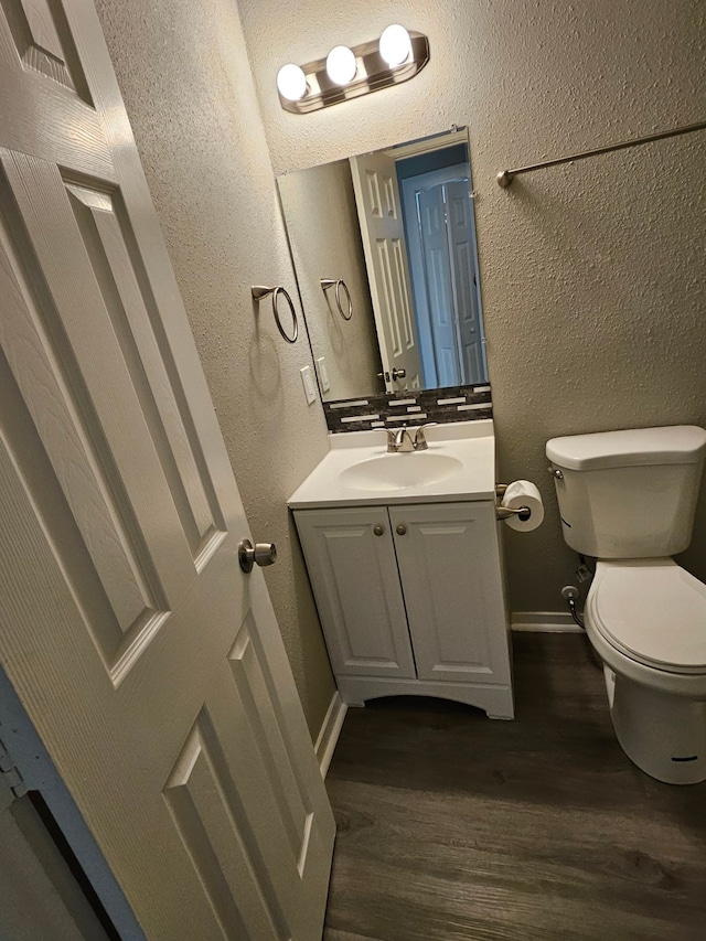 bathroom with vanity, hardwood / wood-style flooring, and toilet