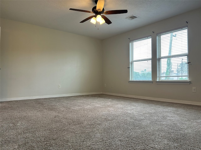 unfurnished room with a textured ceiling, ceiling fan, and carpet flooring