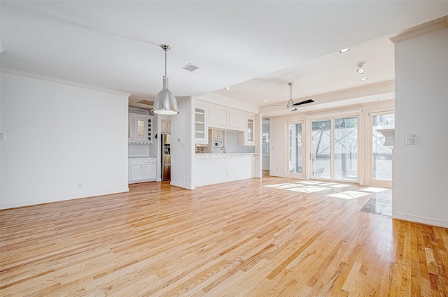 unfurnished living room featuring light hardwood / wood-style flooring, ceiling fan, and ornamental molding