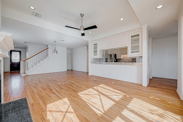 unfurnished living room with ceiling fan, light hardwood / wood-style floors, and ornamental molding