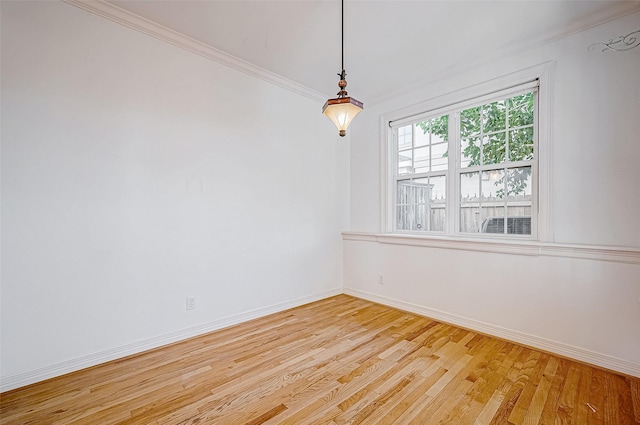 spare room with light hardwood / wood-style floors and crown molding