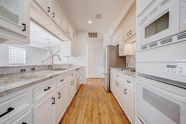 kitchen featuring white cabinets, light wood-type flooring, and stainless steel appliances