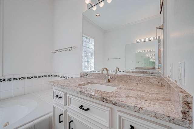 bathroom with vanity, a relaxing tiled tub, and ornamental molding