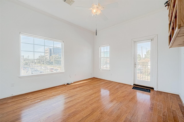 empty room with ceiling fan, light wood-type flooring, and ornamental molding