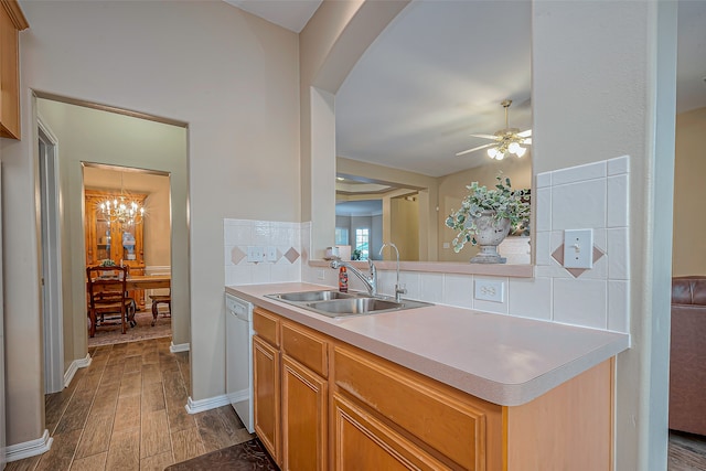 kitchen with ceiling fan with notable chandelier, dark hardwood / wood-style flooring, dishwasher, sink, and tasteful backsplash