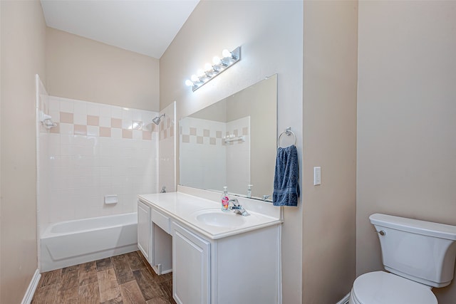 full bathroom with hardwood / wood-style floors, vanity, toilet, and tiled shower / bath combo