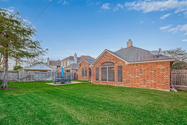 back of property with a yard and a patio area