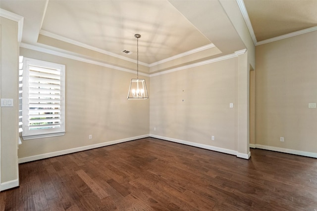 empty room featuring dark hardwood / wood-style flooring, ornamental molding, a raised ceiling, and an inviting chandelier