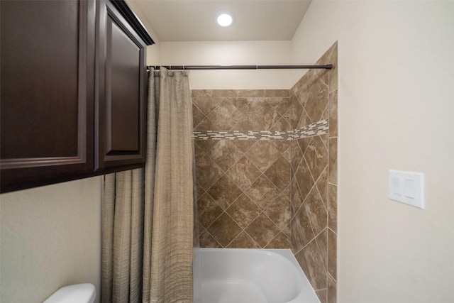 bathroom with shower / bath combination with curtain and toilet