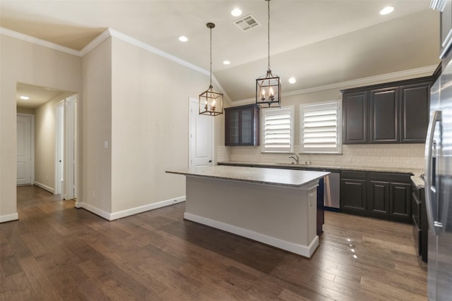 kitchen with pendant lighting, backsplash, dark hardwood / wood-style flooring, ornamental molding, and a center island