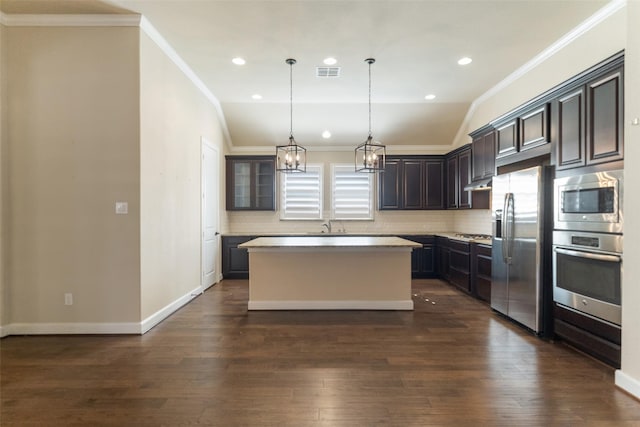 kitchen featuring pendant lighting, a center island, dark brown cabinetry, stainless steel appliances, and crown molding