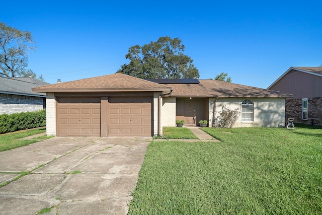 ranch-style home featuring solar panels, a garage, and a front yard