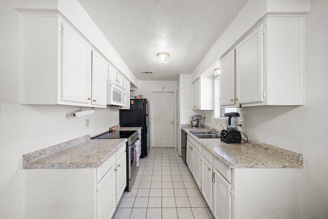 kitchen featuring dishwashing machine, sink, light tile patterned floors, white cabinetry, and stainless steel electric range