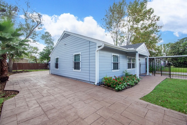 view of side of home with a patio area and a lawn