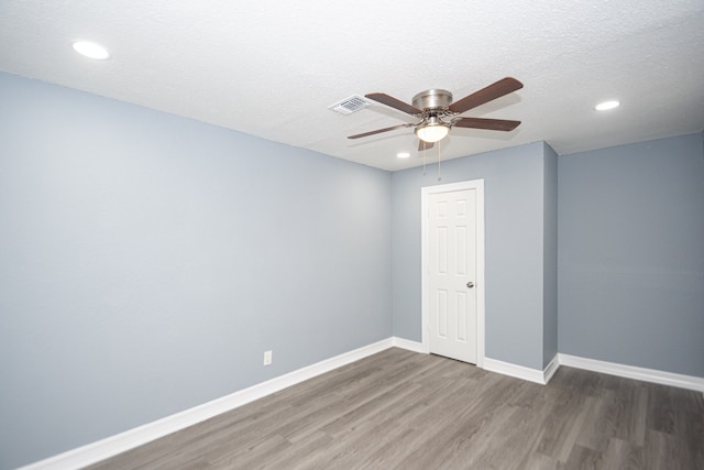 empty room featuring dark wood-type flooring, ceiling fan, and a textured ceiling