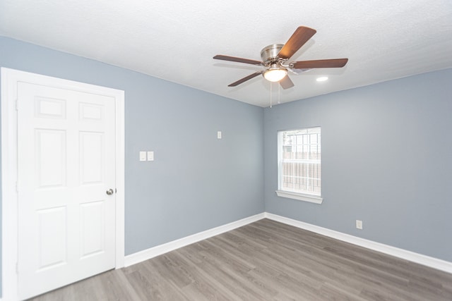 unfurnished room with a textured ceiling, hardwood / wood-style flooring, and ceiling fan