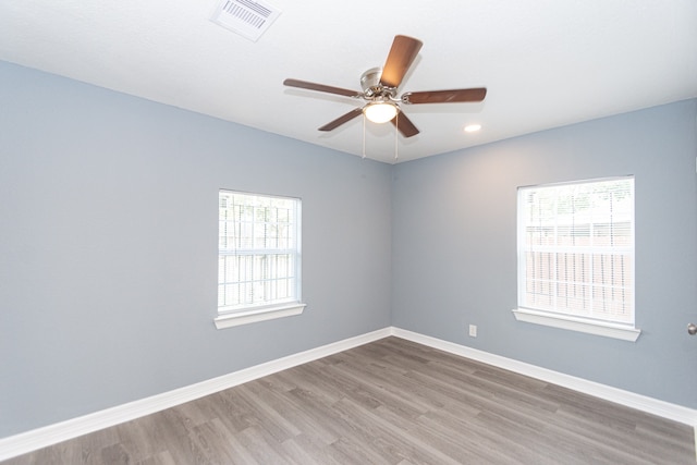 empty room featuring wood-type flooring, ceiling fan, and plenty of natural light