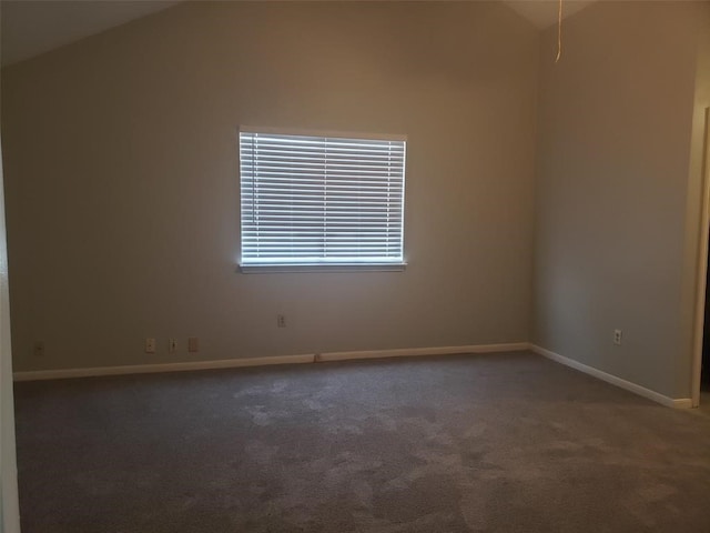 carpeted spare room with vaulted ceiling