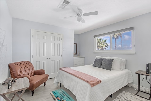 bedroom featuring light hardwood / wood-style floors, ceiling fan, and a closet