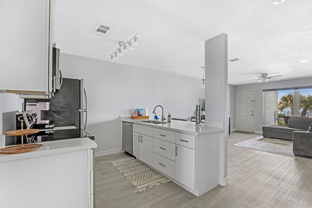 kitchen featuring stainless steel appliances, sink, light hardwood / wood-style floors, white cabinets, and ceiling fan