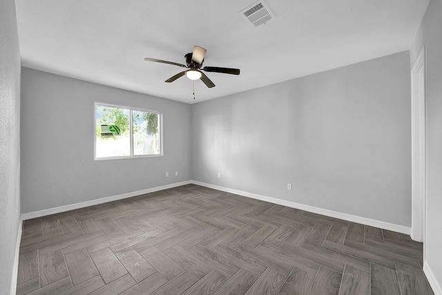 unfurnished room featuring ceiling fan and dark parquet floors