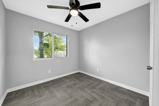 empty room featuring ceiling fan and dark parquet floors