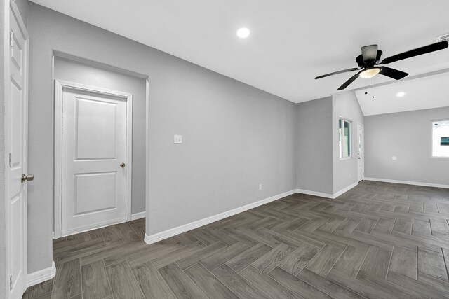 unfurnished room featuring ceiling fan, dark parquet flooring, and vaulted ceiling