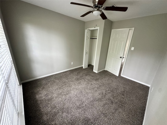 unfurnished bedroom with ceiling fan and dark colored carpet