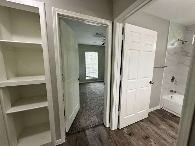 bathroom with tiled shower / bath combo, hardwood / wood-style flooring, and ceiling fan