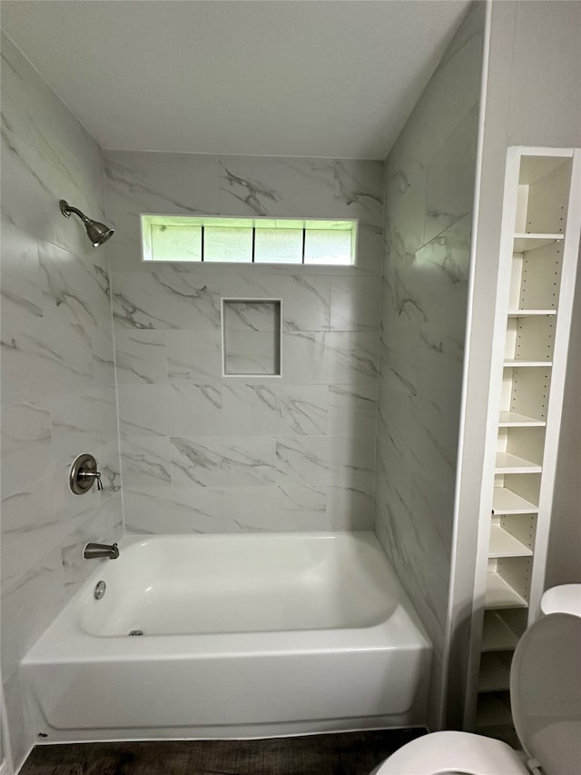 bathroom featuring toilet and tiled shower / bath combo