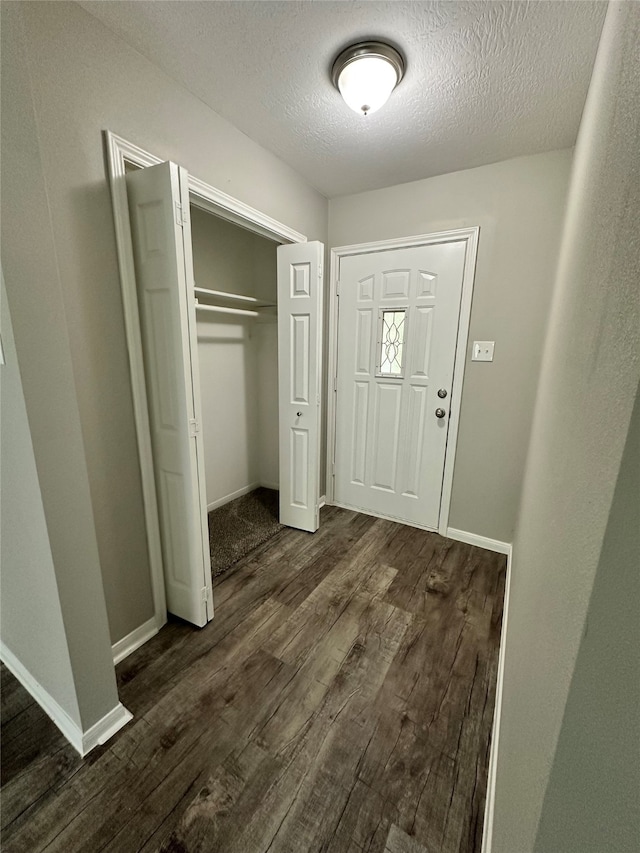 entrance foyer with a textured ceiling and dark hardwood / wood-style floors