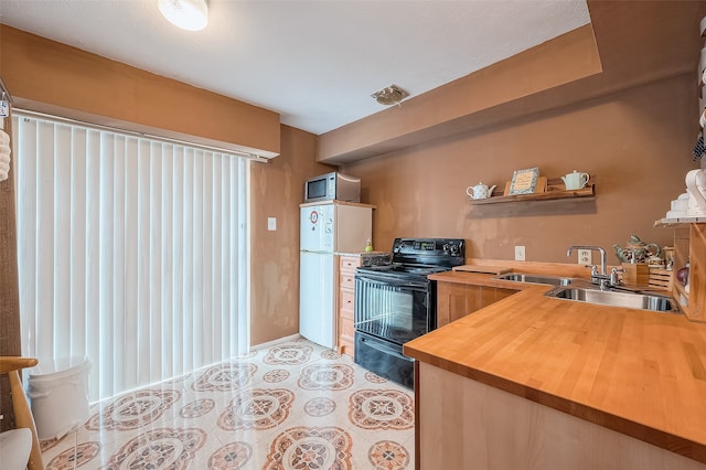 kitchen featuring wooden counters, sink, white refrigerator, and black range with electric stovetop