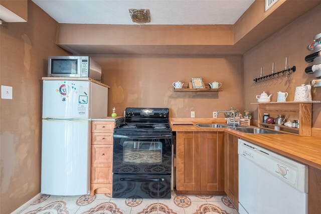 kitchen featuring light tile patterned floors, white appliances, sink, and butcher block countertops