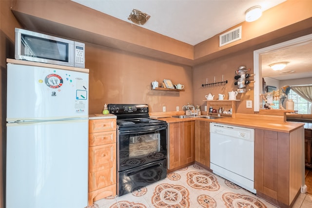 kitchen with butcher block counters, sink, white appliances, and light tile patterned floors