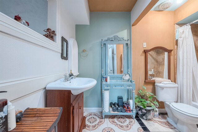 bathroom featuring toilet, vanity, tile patterned floors, and walk in shower