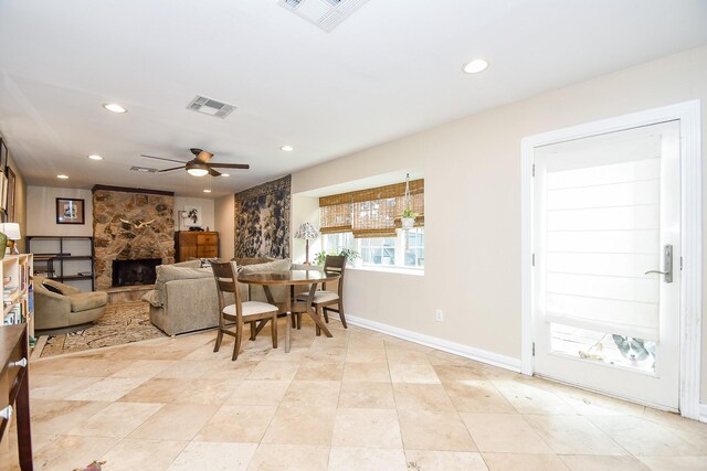 living room with ceiling fan and a fireplace