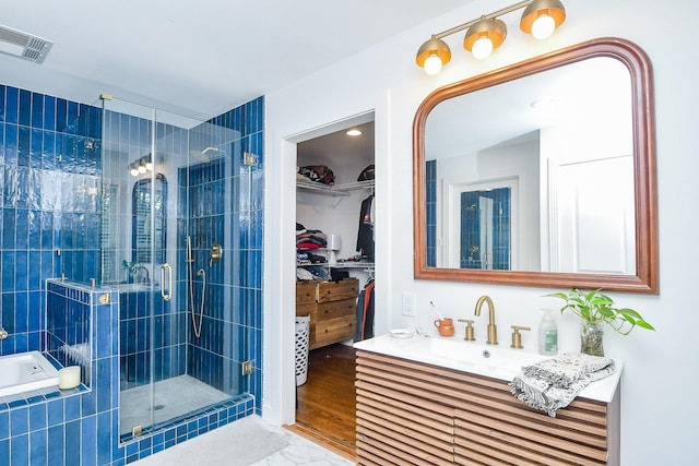 bathroom featuring vanity and a shower with door