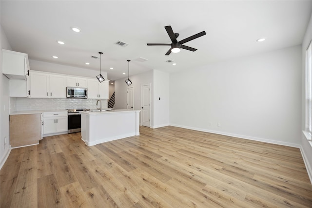 kitchen featuring white cabinetry, stainless steel appliances, light hardwood / wood-style floors, and pendant lighting