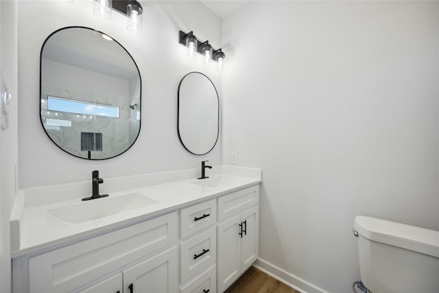 bathroom with toilet, wood-type flooring, vanity, and a shower