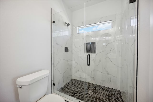 bathroom with toilet and a shower with shower door