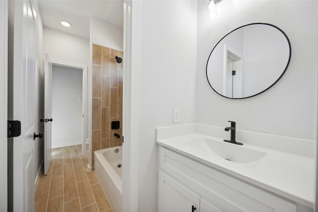 bathroom with tiled shower / bath combo and vanity