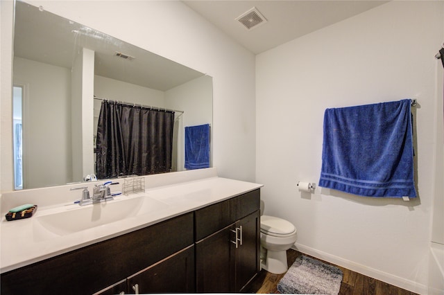 bathroom featuring wood-type flooring, vanity, and toilet