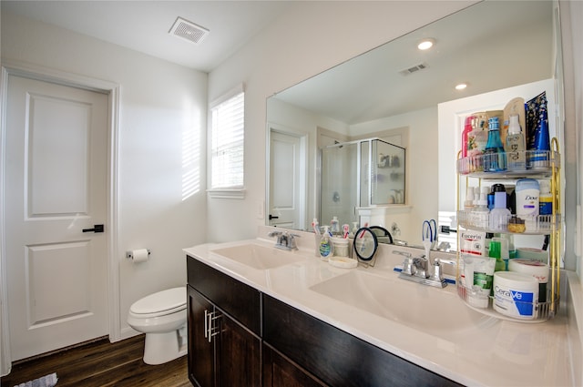 bathroom featuring vanity, hardwood / wood-style flooring, toilet, and a shower with shower door