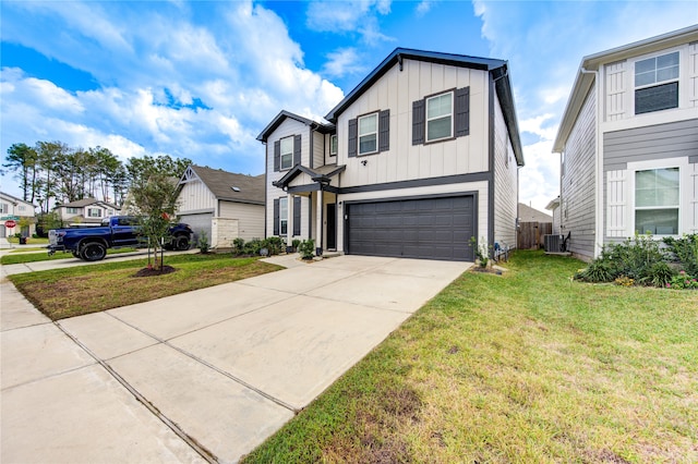 view of front of property featuring a garage, cooling unit, and a front lawn