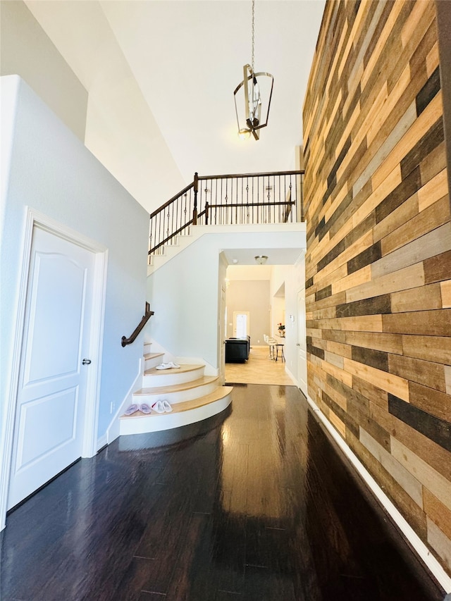 interior space with wood walls, hardwood / wood-style flooring, and a towering ceiling