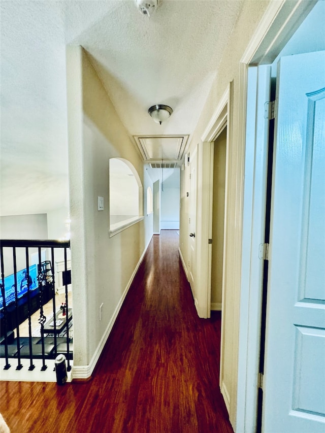 corridor with dark hardwood / wood-style flooring and a textured ceiling