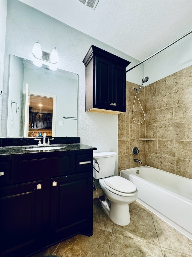 full bathroom featuring tile patterned floors, vanity, a textured ceiling, tiled shower / bath combo, and toilet